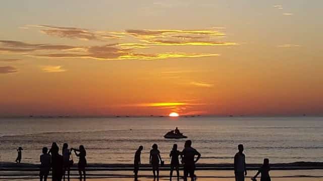 Tourists enjoying the beautiful sunrise at Cửa Lò Beach, Vietnam.