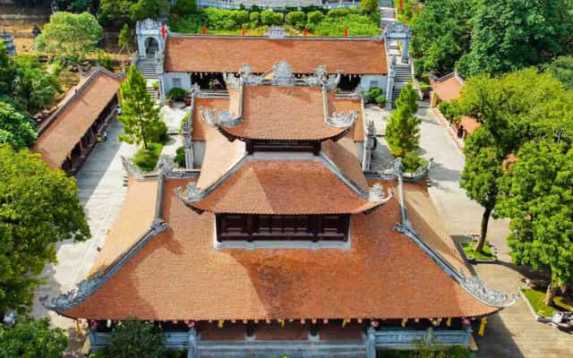 Góc chụp từ trên cao cận cảnh mái ngói đỏ rêu phong và các tầng mái đao cong đặc trưng của kiến trúc Chùa Côn Sơn