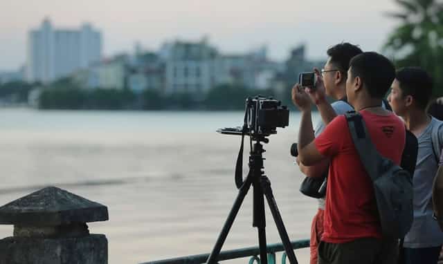 Du khách nước ngoài mê mẩn ngắm hoàng hôn ở Hồ Tây