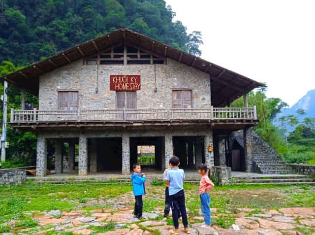 Đám trẻ làng đá chơi đùa ở sân nhà cộng đồng của bản