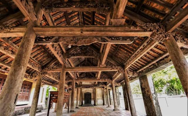 The communal house's architecture, crafted from jackfruit wood, features exquisite and intricate patterns.
