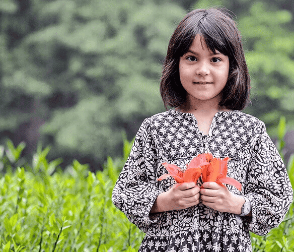 A foreign girl delightedly plays with the kapok flowers