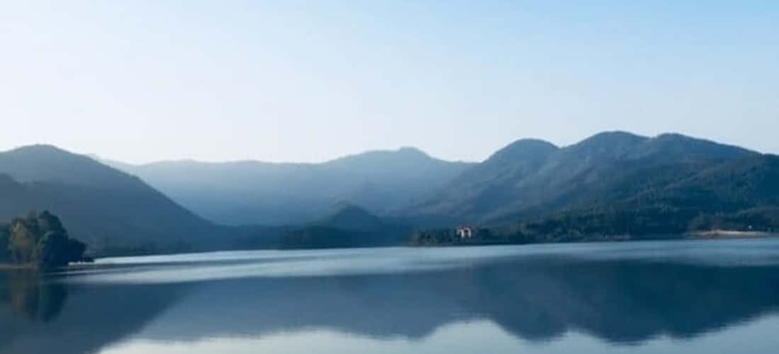 湖面平静而宁静,远处是百叶窗山。