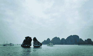 Nhìn từ xa, hòn Trống Mái dựng đứng sừng sững giữa mặt nước trong xanh